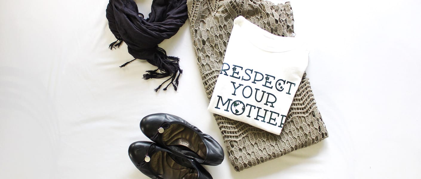 green skirt with white t-shirt that says "respect your mother" with black scarf and black ballet flats on white surface