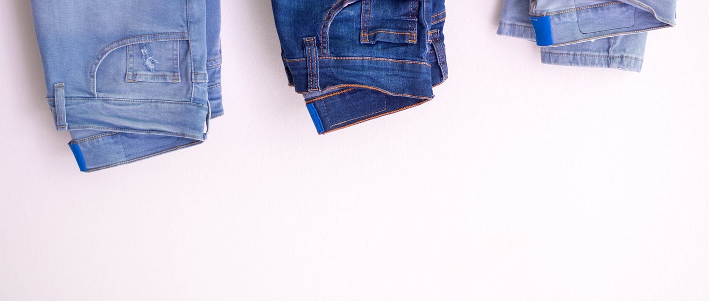 three pairs of jeans against white background