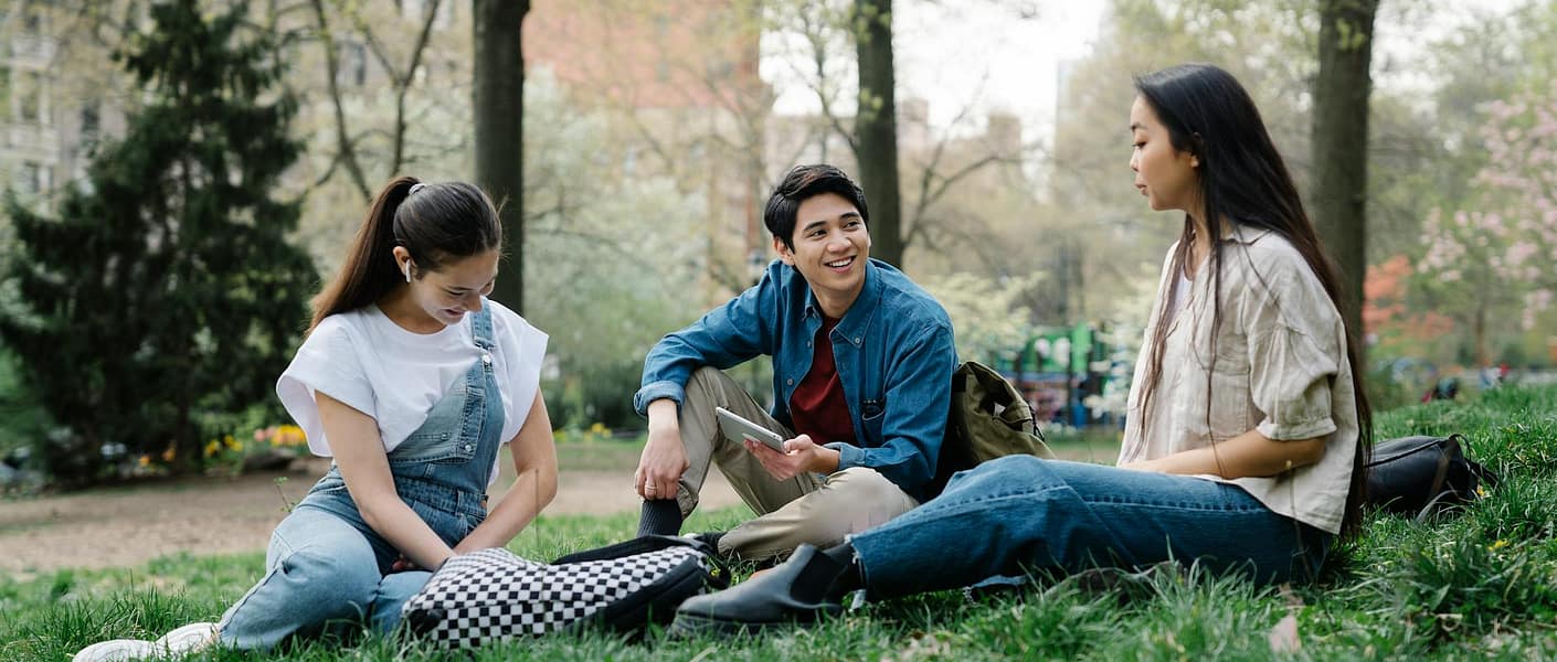 photo of a group of friends sitting on the grass