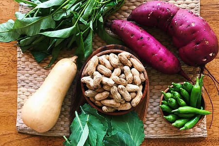 swee potatoes, squash, greens, peanuts laid out on bamboo mat