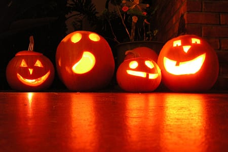 carved pumpkins lit up in the dark