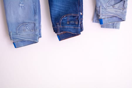 three pairs of jeans against white background