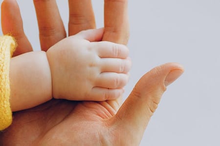 person holding babys hand