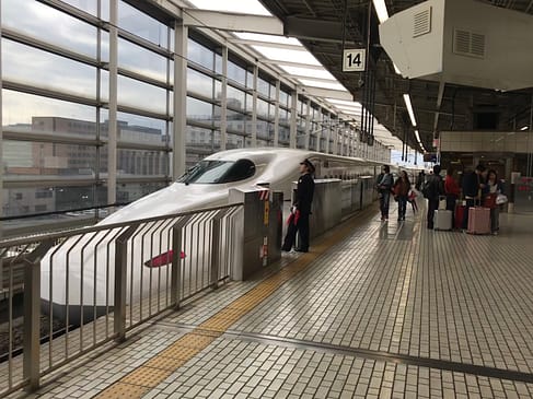 Bullet train pulling up to gated train platform 