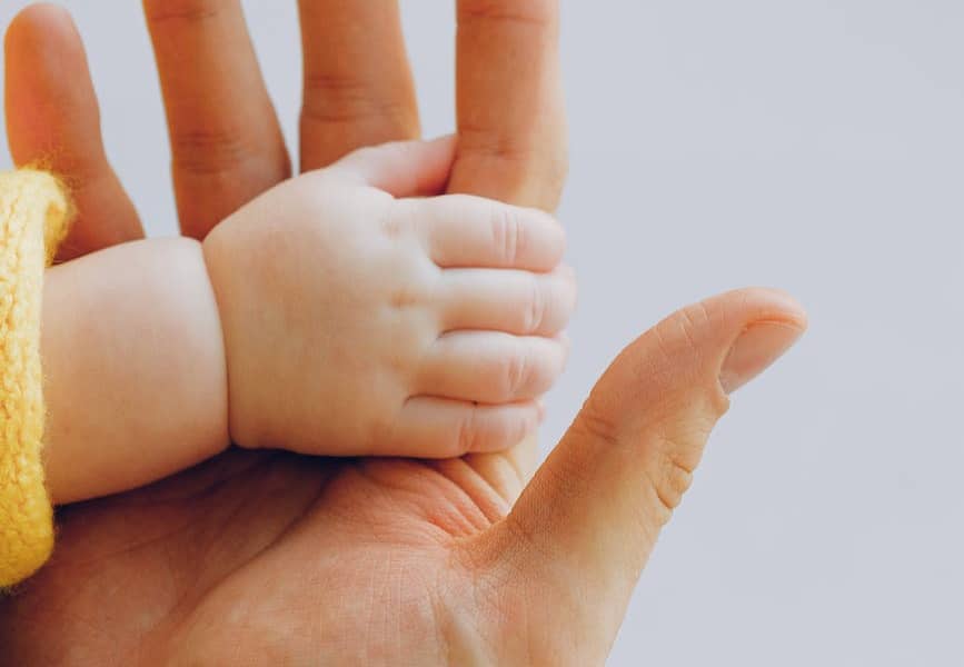 person holding babys hand